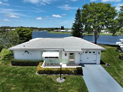 ranch-style house with a water view, a front lawn, and a garage