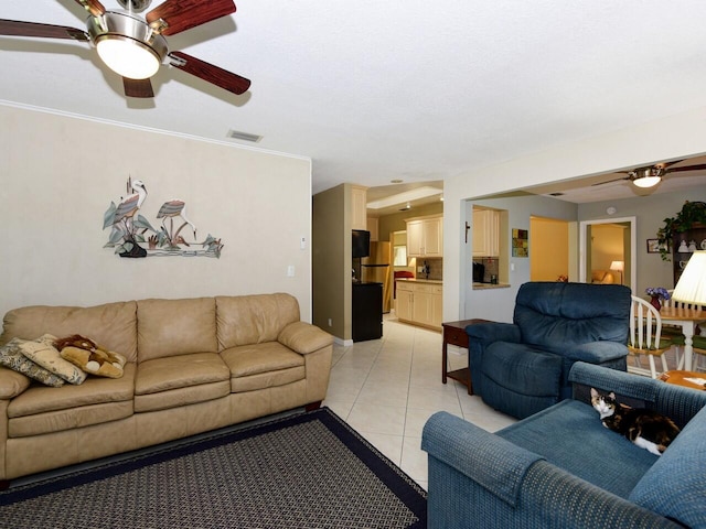 tiled living room with ceiling fan and crown molding