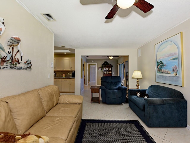 tiled living room with ceiling fan and crown molding