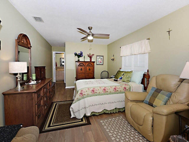 bedroom featuring dark hardwood / wood-style floors, ceiling fan, and ensuite bathroom