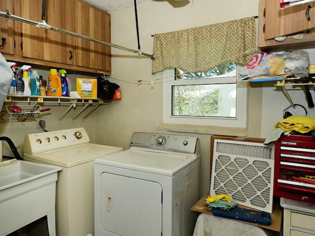 laundry area with cabinets, sink, and washing machine and dryer