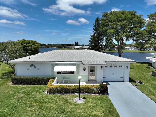 ranch-style home with a front yard, a garage, and a water view