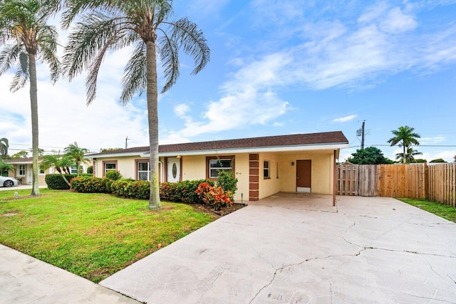 single story home featuring a front lawn and a carport