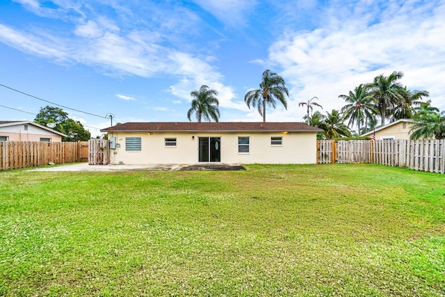 rear view of house featuring a yard and a patio area