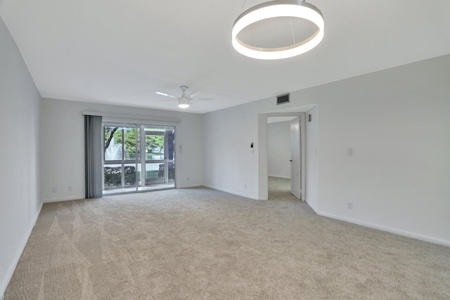 spare room with light colored carpet and ceiling fan