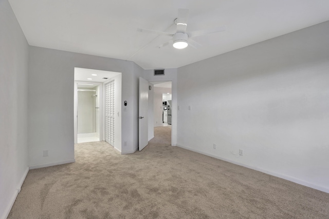 empty room featuring ceiling fan and light carpet