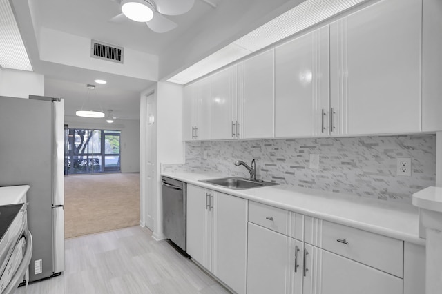 kitchen with light carpet, ceiling fan, white cabinetry, dishwasher, and sink