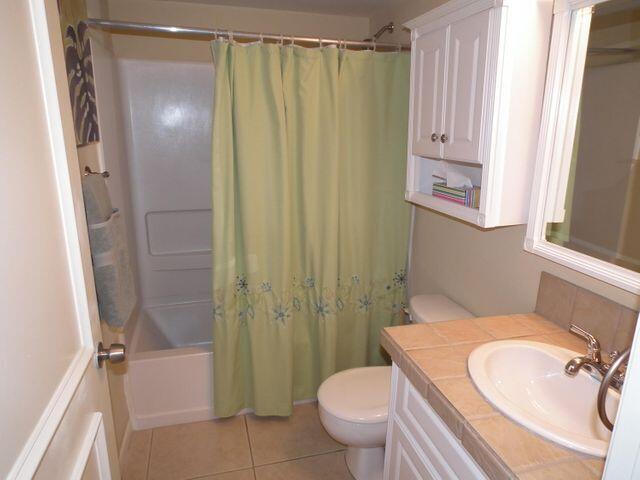 full bathroom featuring tile flooring, shower / bath combo, toilet, and large vanity