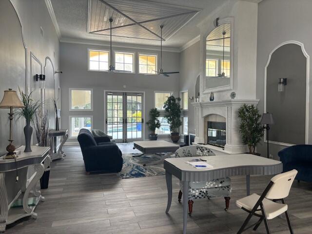 interior space featuring french doors, ornamental molding, wood-type flooring, and a high ceiling