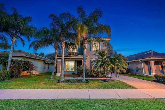 mediterranean / spanish home featuring a front lawn