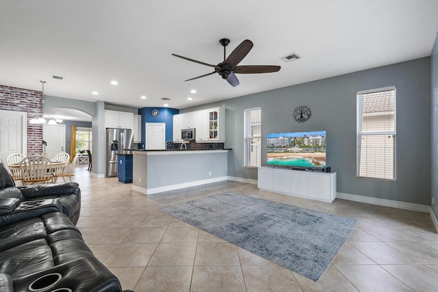 tiled living room with ceiling fan