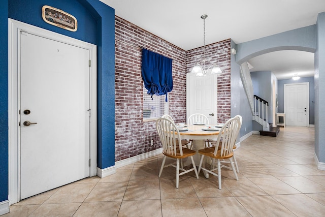 tiled dining area featuring brick wall