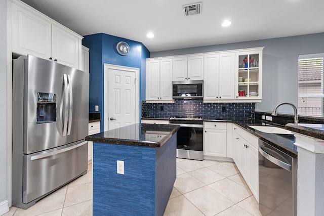 kitchen featuring sink, appliances with stainless steel finishes, dark stone counters, and white cabinets