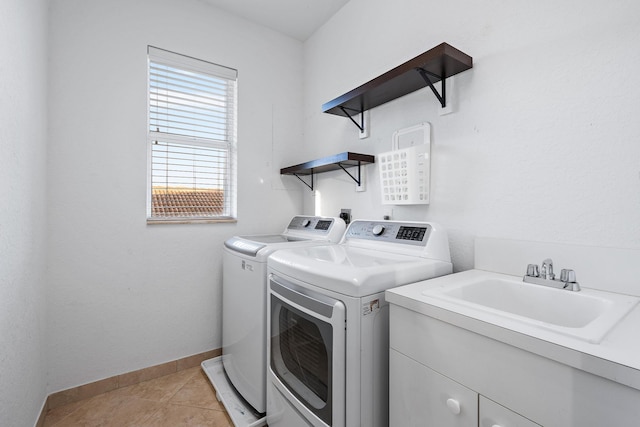 washroom featuring sink, washer and dryer, cabinets, and light tile patterned floors