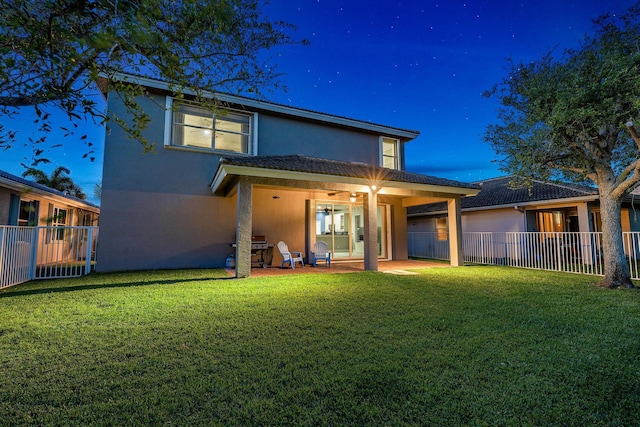 rear view of property with a patio and a lawn