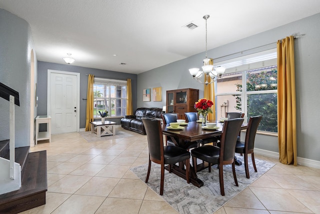 dining area with a chandelier and light tile patterned flooring