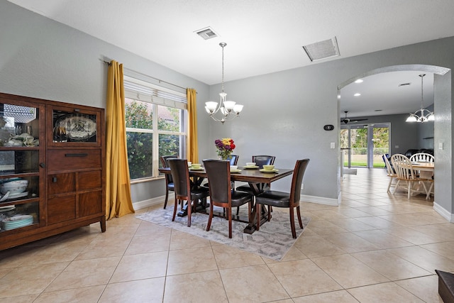 dining area with light tile patterned floors, ceiling fan with notable chandelier, and a wealth of natural light