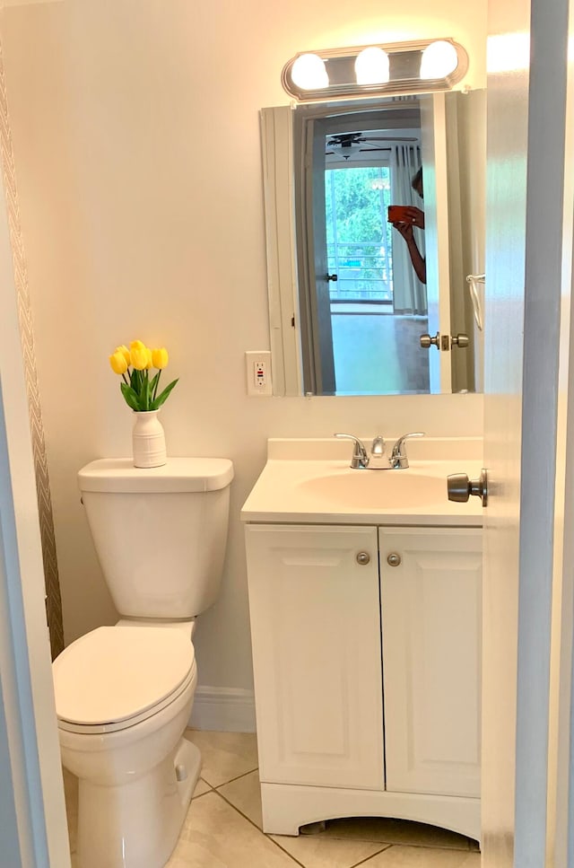 bathroom featuring tile flooring, toilet, and vanity