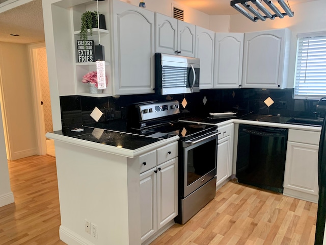 kitchen featuring stainless steel appliances, backsplash, white cabinetry, and light hardwood / wood-style floors