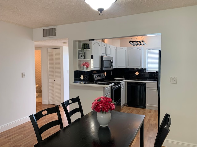 kitchen featuring stainless steel appliances, white cabinets, a textured ceiling, light hardwood / wood-style floors, and tasteful backsplash