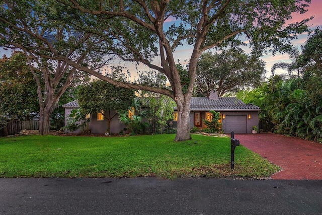 view of front of home with a garage and a yard