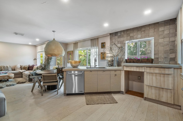 kitchen featuring tile walls, light hardwood / wood-style floors, stainless steel dishwasher, sink, and pendant lighting