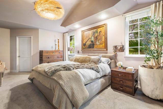 carpeted bedroom featuring lofted ceiling and multiple windows