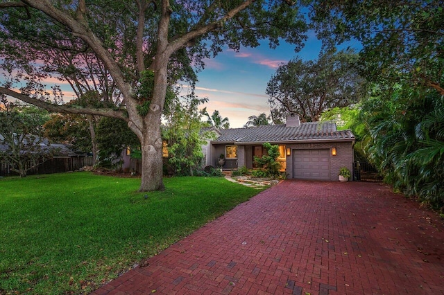 view of front of home with a garage and a lawn