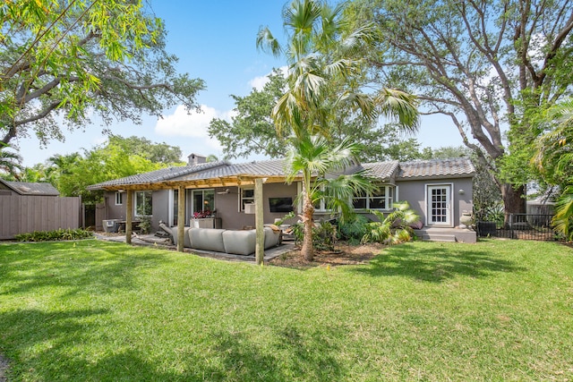 rear view of property featuring a lawn and an outdoor living space