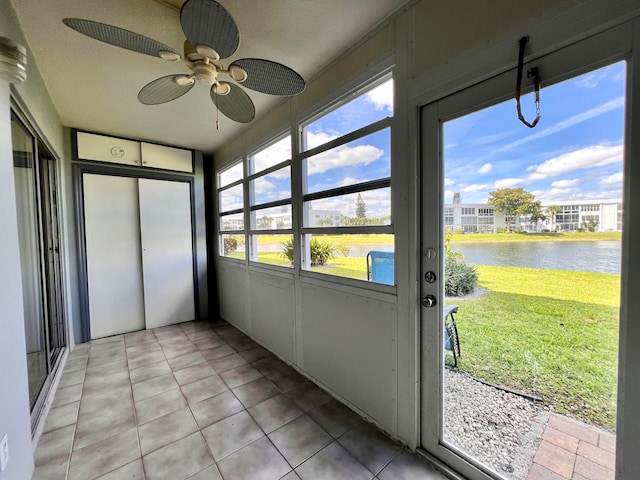 unfurnished sunroom with a water view and ceiling fan