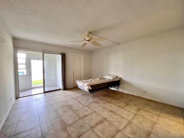 unfurnished bedroom with ceiling fan, a textured ceiling, light tile patterned floors, and access to outside