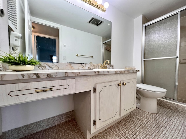 bathroom featuring tile patterned flooring, vanity, toilet, and a shower with door