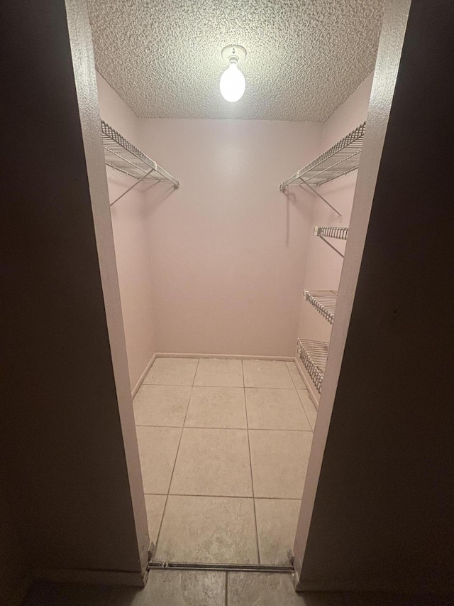 spacious closet with light tile patterned floors