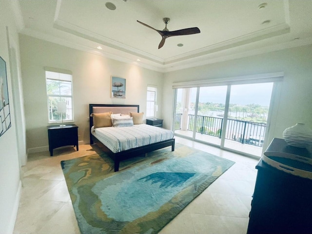 bedroom with access to outside, a tray ceiling, and multiple windows