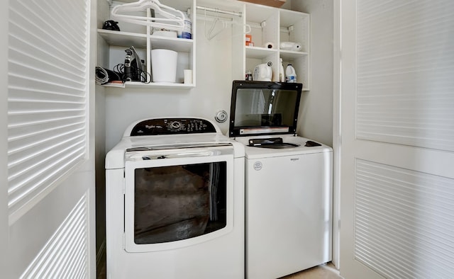 clothes washing area with washer and clothes dryer