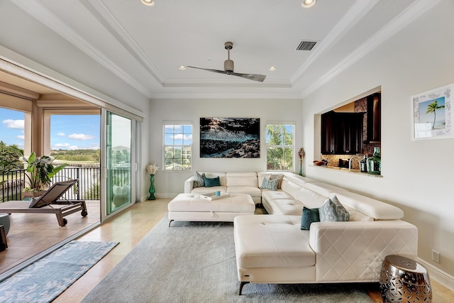 tiled living room featuring ceiling fan, crown molding, and a wealth of natural light