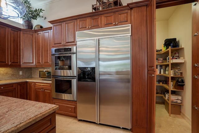 kitchen with backsplash, light stone countertops, and stainless steel appliances