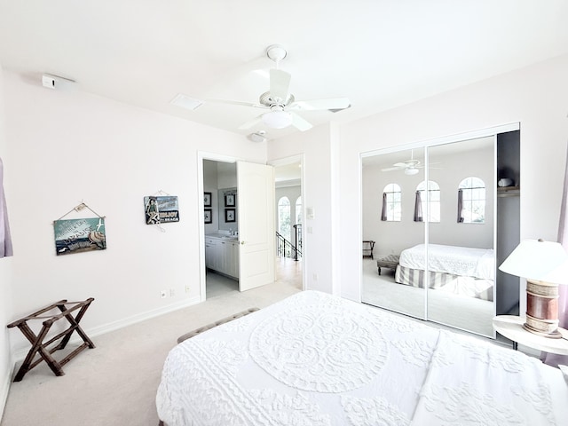 carpeted bedroom with ceiling fan and a closet