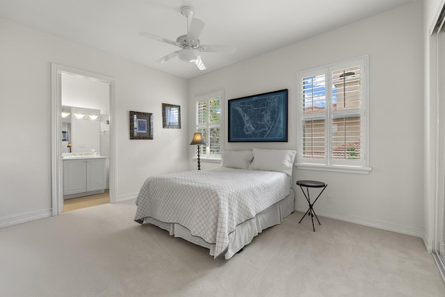 carpeted bedroom with ceiling fan and ensuite bath