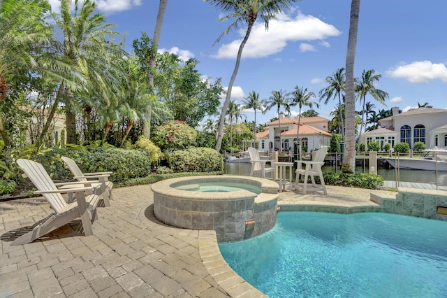 view of swimming pool featuring a patio and an in ground hot tub