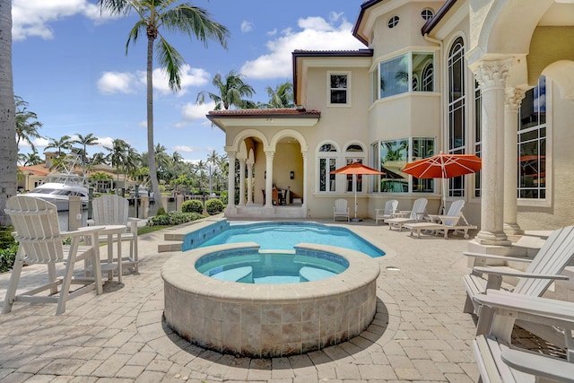 view of pool featuring a patio and an in ground hot tub