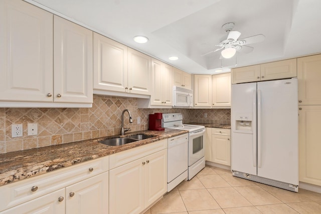 kitchen with tasteful backsplash, ceiling fan, white appliances, a raised ceiling, and sink