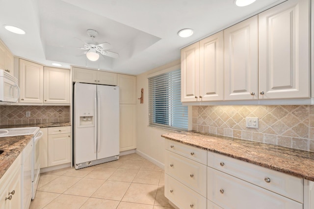 kitchen with backsplash, light tile floors, light stone countertops, ceiling fan, and white appliances