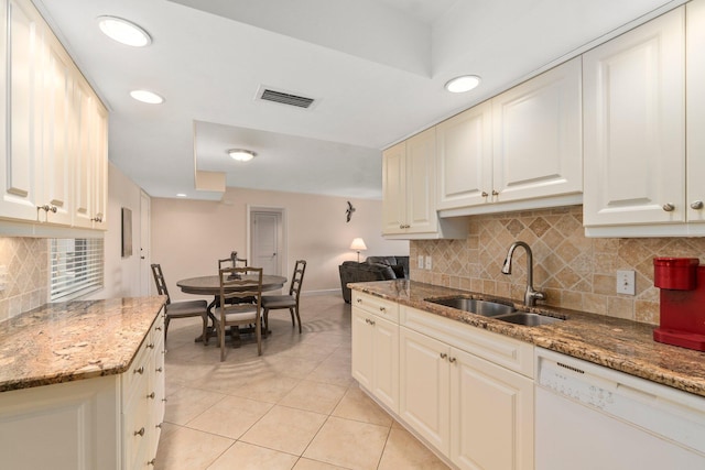 kitchen with light tile floors, stone countertops, sink, white dishwasher, and tasteful backsplash