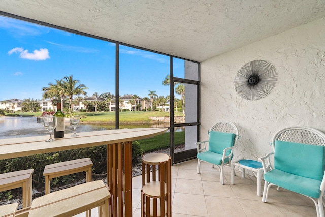 sunroom featuring a water view