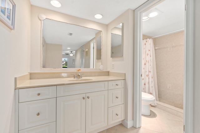 bathroom with walk in shower, tile floors, ceiling fan, toilet, and vanity with extensive cabinet space