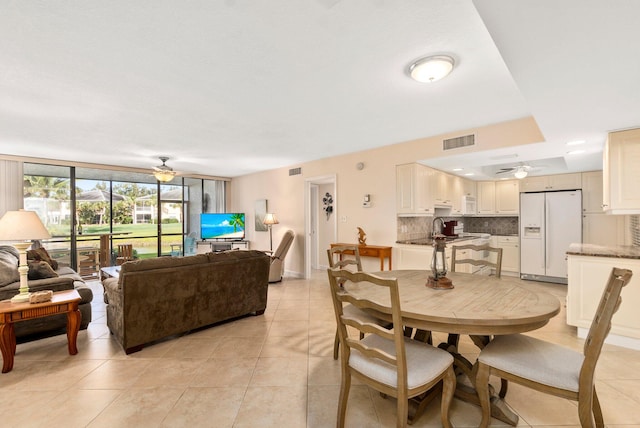 tiled dining space with ceiling fan