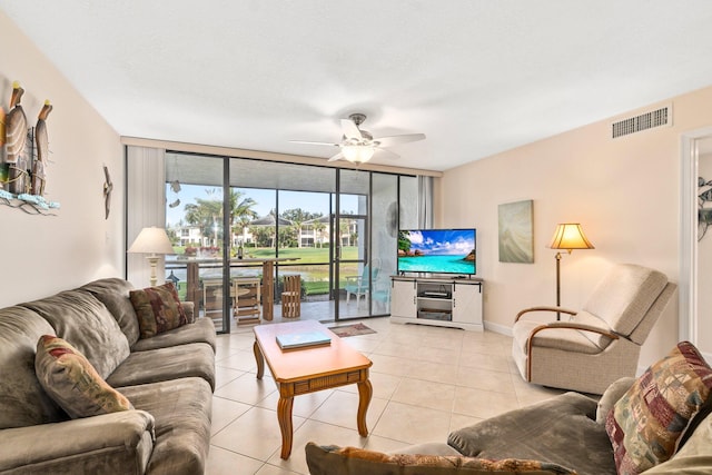 tiled living room with ceiling fan and expansive windows