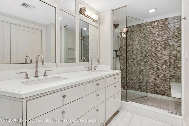 bathroom featuring an enclosed shower and double sink vanity