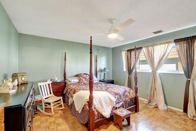 bedroom featuring ceiling fan, a textured ceiling, and light parquet flooring